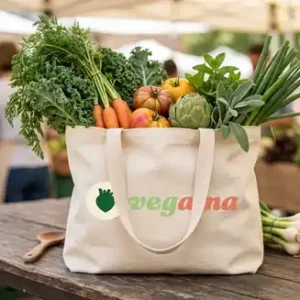 Cream canvas tote bag with the Vegama logo, filled with fresh vegetables